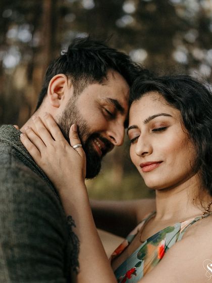 A close-up capturing a gentle touch and happy smiles. This intimate shot in the forest highlights the small gestures of affection that mean so much.