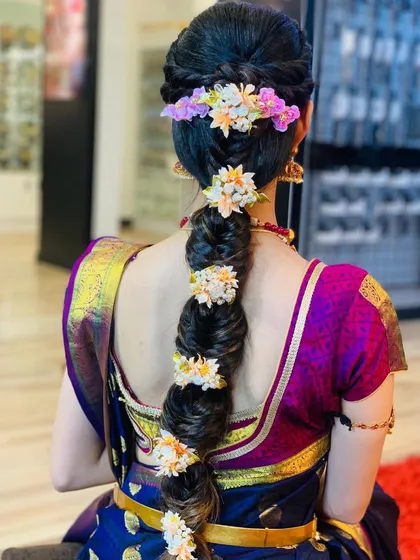 A hairstyle can complete the entire bridal look. This is a traditional South Indian braid, intricately woven and adorned with fresh flowers. I specialize in creating such elaborate and secure hairstyles that last throughout the wedding rituals.
