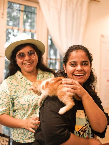 A ginger kitten playfully climbs on a participant's shoulder, adding an extra layer of fun to the event.