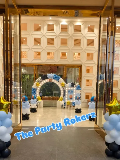 A wide shot of the Boss Baby themed entrance at a banquet hall. The lighted arch and balloon pillars create an impressive welcome.
