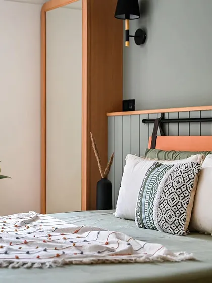 A sneak peek of the master bedroom, inspired by earthy, muted tones. The headboard combines a leather-look panel with a painted grooved backboard, creating a mix of textures.