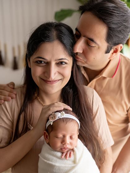 A tender moment between new parents and their baby. The father's gentle kiss on the mother's head is so sweet.