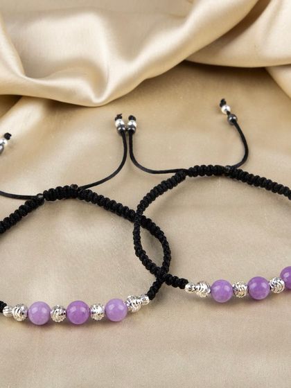 A pair of adjustable anklets with purple beads and silver accents.