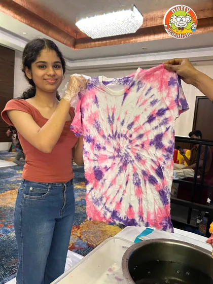 A stunning spiral pattern created with purple and pink dyes. Our tie-dye workshops are a lesson in color theory and chemical reactions.