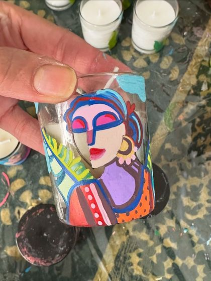 A candle painted with one of my signature abstract womanhood designs.