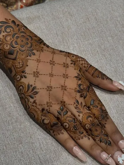 This elegant back-of-hand design features a delicate jaal pattern framed by intricate floral borders, a classic Arabic style.