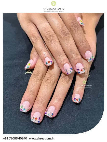 A minimalist look with a touch of sparkle. I created a clean French manicure style on these short, natural nails and lined the tips with tiny, colorful rhinestones for a fun and subtle finish.