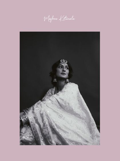 A classic black and white portrait. The soft light on the bride's chikankari saree highlights the delicate texture and craftsmanship of her outfit.