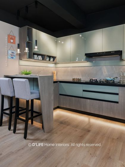 This compact kitchen with a breakfast bar showcases smart space utilization. The two-tone cabinets in grey and a soft mint green add a touch of modern color and style.