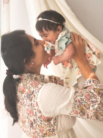 Lifting her baby up, full of joy and love. I encourage parents to play and interact naturally with their children during our sessions to capture these genuine moments.