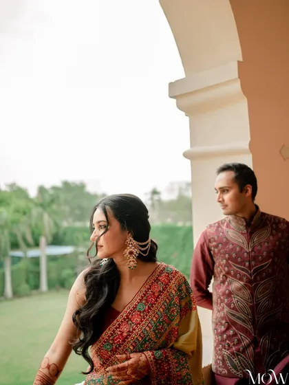 A close-up of the couple, her side profile highlighting the intricate hairstyle and soft, natural makeup.