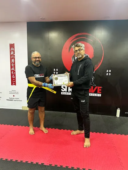 The same student proudly receives his certificate, an inspiration to everyone at our academy.