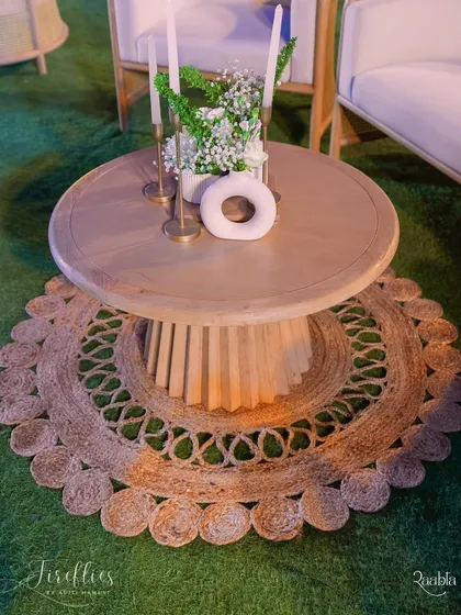 A detail shot of the lounge area, showing a jute rug and a modern wooden coffee table, blending natural textures with contemporary design.