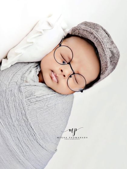 A full-body view of the baby wrapped in grey.