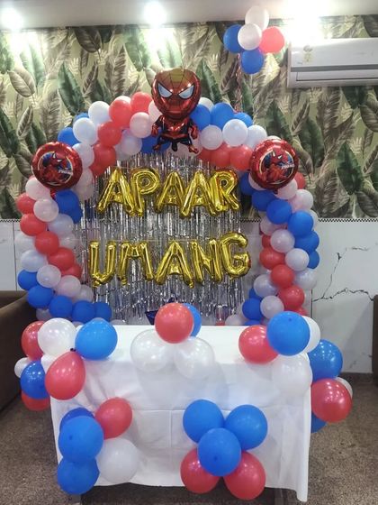 A Spiderman-themed birthday decoration with a balloon arch over the main table, perfect for a cake-cutting ceremony.