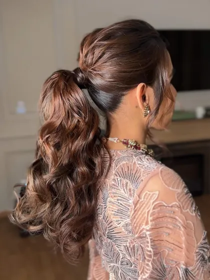 The back of the curly ponytail, showing the texture and detail of the curls. I use extensions to create this full, luscious look.