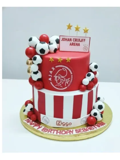 I can create detailed cakes for any fan, like this two-tier Ajax football club cake. Made with an eggless chocolate choco-chip flavor, it features the club's logo and colors, perfect for a dedicated sports enthusiast.