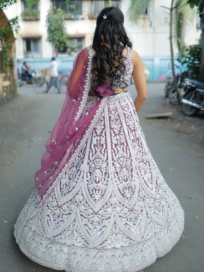 The back view of this stunning purple lehenga with heavy silver embroidery, showing off the beautiful hairstyle and dupatta.