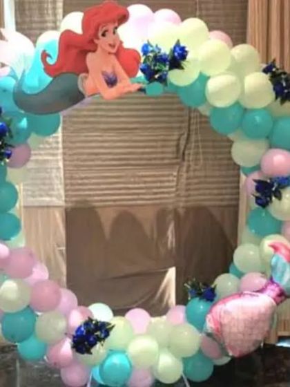 A Little Mermaid themed balloon ring. The pastel-colored balloon arch is decorated with an Ariel cutout and mermaid tail foils.