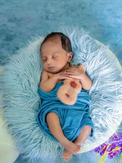 A tiny musician dreaming of his first song. I love adding small, personal touches like this miniature guitar to make each photoshoot unique.