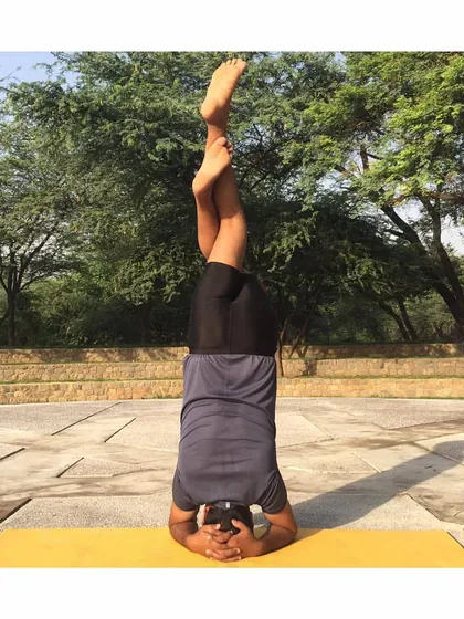 Garudasana (Eagle Pose) legs in Sirsasana (Headstand) is an advanced variation that requires immense focus and control. It combines the benefits of an inversion with a deep stretch for the hips and thighs.