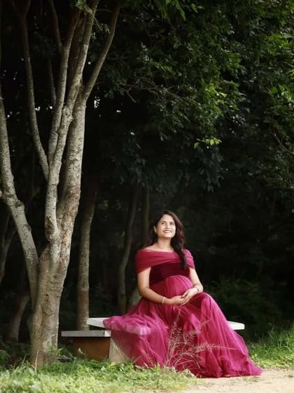 A quiet moment of reflection. This client chose a simple yet elegant maroon maternity gown for her outdoor photoshoot, and the result is timeless.