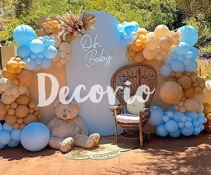 This outdoor baby shower setup combines the teddy bear theme with boho-chic elements. The wicker peacock chair, pampas grass, and an earthy-toned balloon garland create a stylish and relaxed vibe.