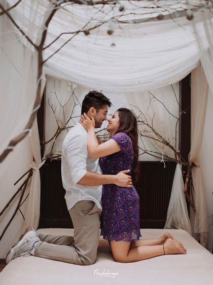 A tender, kneeling pose on the indoor bed set, full of romance.