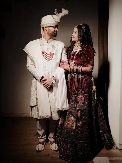 A stylish wedding day portrait of the couple. The groom has his arm around the bride as they look at each other, captured with dramatic lighting that creates a cinematic feel.