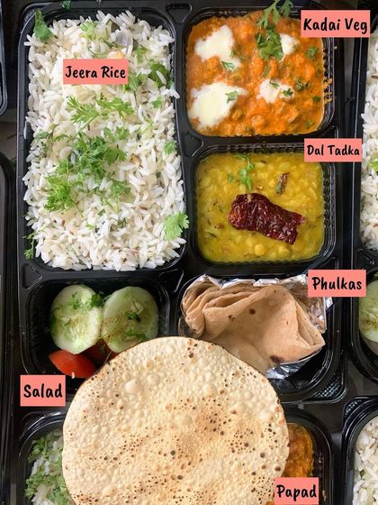 A classic North Indian thali, ready for your journey. It comes with soft Phulkas, Jeera Rice, creamy Dal Tadka, rich Kadai Veg, a fresh salad, and a crispy papad.