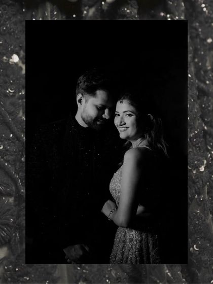 An intimate black and white couple portrait, framed with a sparkling border, capturing a quiet and happy moment in the dark.