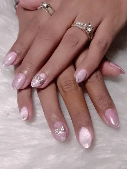 A soft and feminine design with a shimmery pink base, accented with delicate rhinestone bow charms.