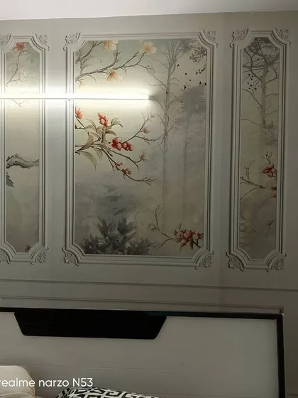 Here, I installed classic wainscoting panels behind a bed, using a delicate chinoiserie wallpaper inside the frames. This technique gives the illusion of intricate wall panels and adds a timeless, decorative touch to the bedroom.