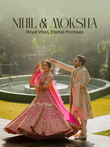 A royal portrait of the couple in a beautiful garden setting. The groom gently adjusts the bride's dupatta, a small gesture full of love and care.