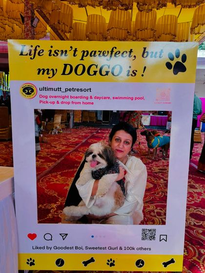 A pet parent poses with her Shih Tzu inside our custom Instagram-style photo frame that reads, "Life isn't pawfect, but my DOGGO is!". It is one of our most popular photo ops.