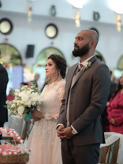 The couple during their wedding ceremony. The bride's side profile shows off her elegant updo and soft, glowing makeup.