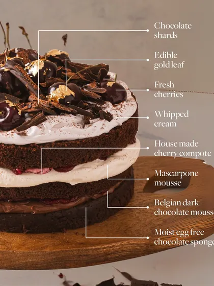 A detailed breakdown of my Black Forest cake, showing every decadent layer: moist sponge, Belgian dark chocolate mousse, mascarpone mousse, cherry compote, fresh cherries, and chocolate shards.