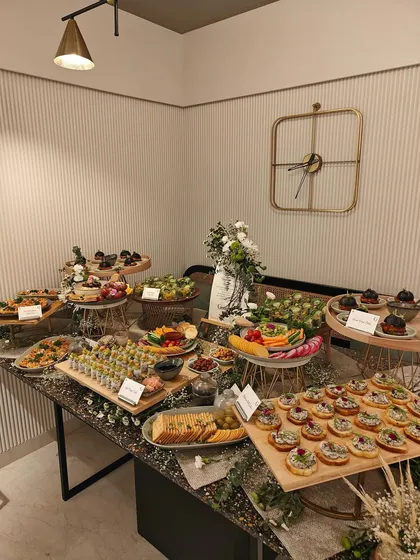 A full view of our stunning Asian grazing table, designed for a festive gathering. This image displays the beautiful arrangement of sushi, sliders, salads, and crostini on a modern black marble table.