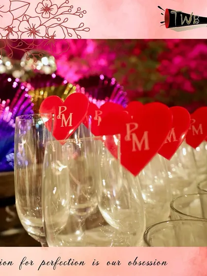 Custom heart-shaped glass markers with the couple's initials, adding a romantic and personal touch to the reception at Saltt, Karjat.