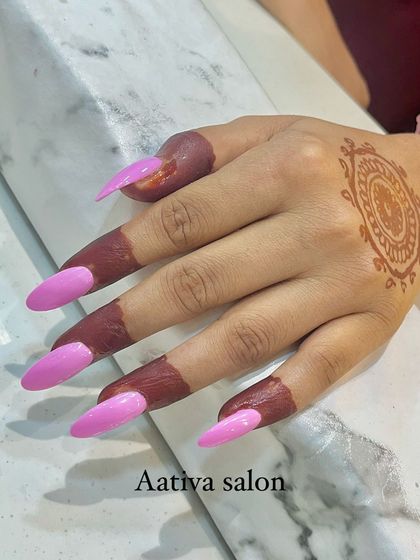 A fun and vibrant choice. These long, stiletto-shaped nails are painted with a bright, glossy pink polish.