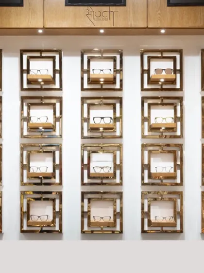 The wall display features individual frames made of wood and brass, creating a unique and artistic way to showcase premium eyewear.