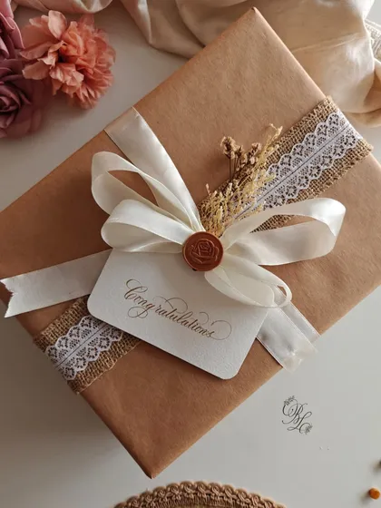 It’s the little details that make a gift unforgettable. This package is wrapped with rustic burlap and lace ribbon, dried flowers, a wax seal, and a "Congratulations" tag.