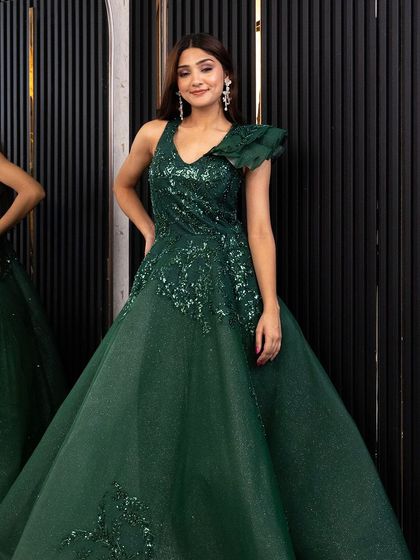 A full-length shot of the emerald green gown, showing its beautiful A-line silhouette and one-shoulder ruffle detail.