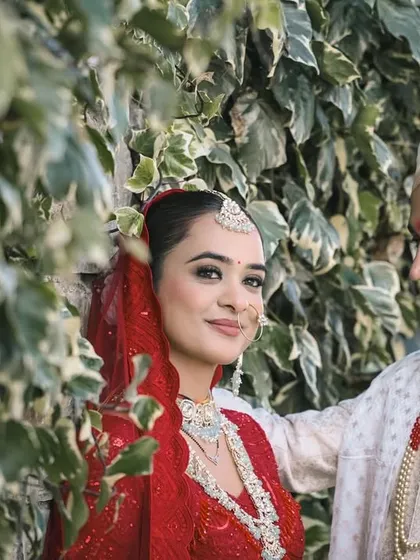 A beautiful portrait of the couple against a wall of ivy, the groom looking lovingly at his bride.