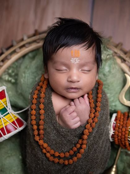 A beautiful close-up portrait that brings all the focus to the baby's face and the carefully placed props, creating a powerful and intimate image.