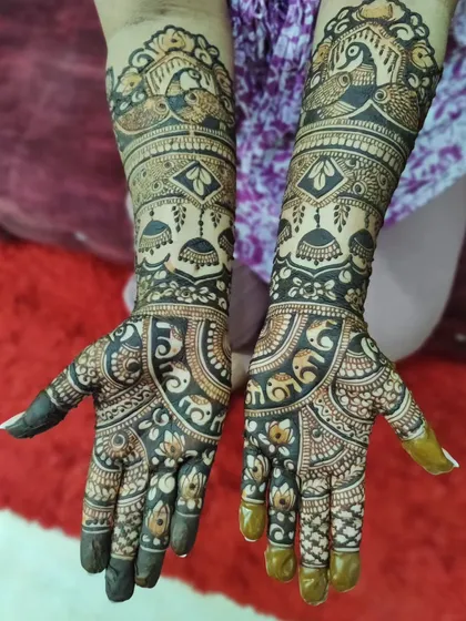 A stunning example of a heavy, full-coverage bridal design. The dark stain makes the intricate details like elephants, birds, and jhumkas pop beautifully.