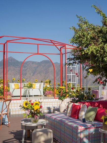 The mountain range provides a breathtaking natural backdrop for the colorful and modern decor structures.