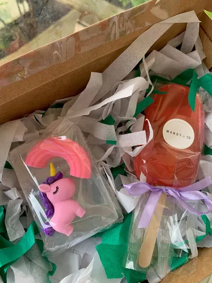 A magical unicorn-themed gift box with a unicorn eraser soap and a strawberry-scented popsicle soap, perfect for little hands.