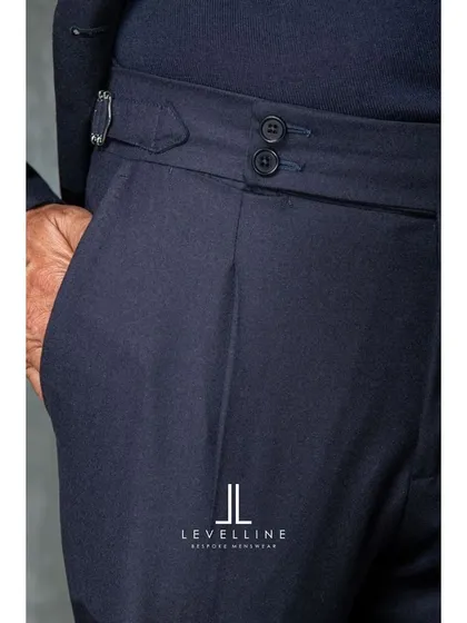 The details of our bespoke trousers, including pleated fronts and side adjusters. These elements not only add style but also enhance comfort and movement.