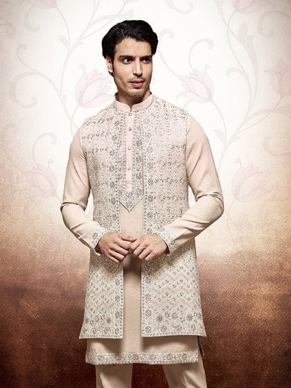 This beige kurta and jacket set is a study in subtle sophistication. The intricate, tone-on-tone embroidery on the jacket adds a layer of texture and luxury.